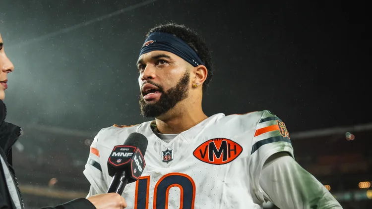 File photo from 13 October 2025: Caleb Williams in his Bears No. 18 jersey answering questions in a postgame television interview at Washington, a year before this press conference. It does not show the Minnesota game or Thursday's media session. The 16:9 cropped derivative is offered under the same CC BY-SA 4.0 licence.