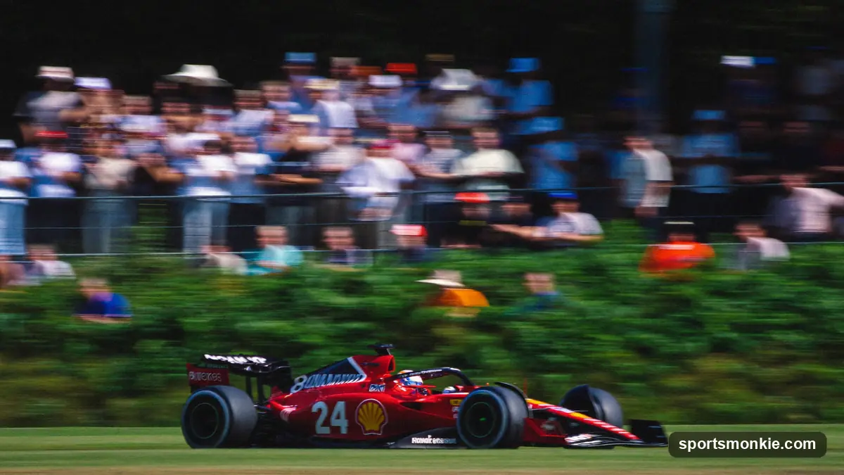Formula 1 fans watching from a grassy general admission viewing area at a Grand Prix