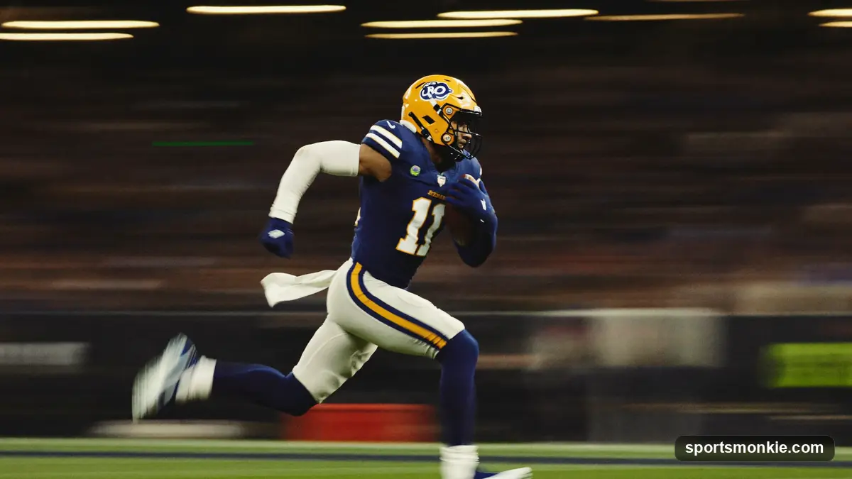 NFL wide receiver sprinting down the sideline at full speed under stadium lights