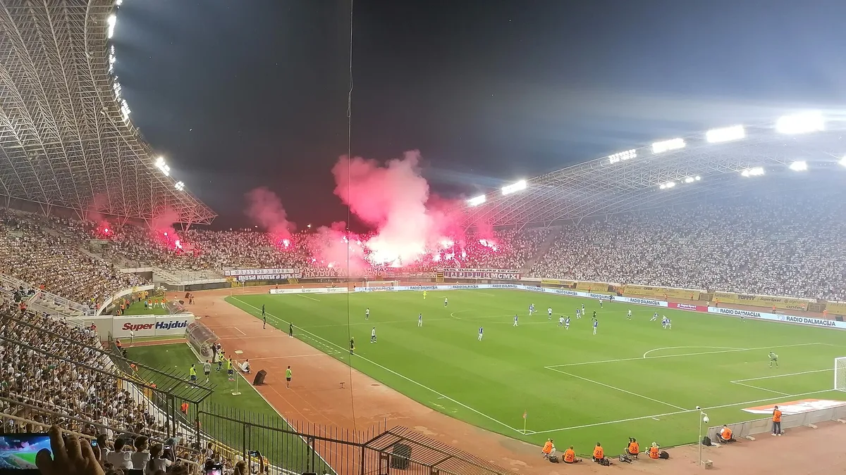 File photo from 13 August 2023: a pyrotechnic display by Hajduk Split supporters at Poljud Stadium during a match against Slaven Belupo. It does not show the October 2026 match against Ajax. The 16:9 cropped derivative is offered under the same CC BY-SA 4.0 licence.