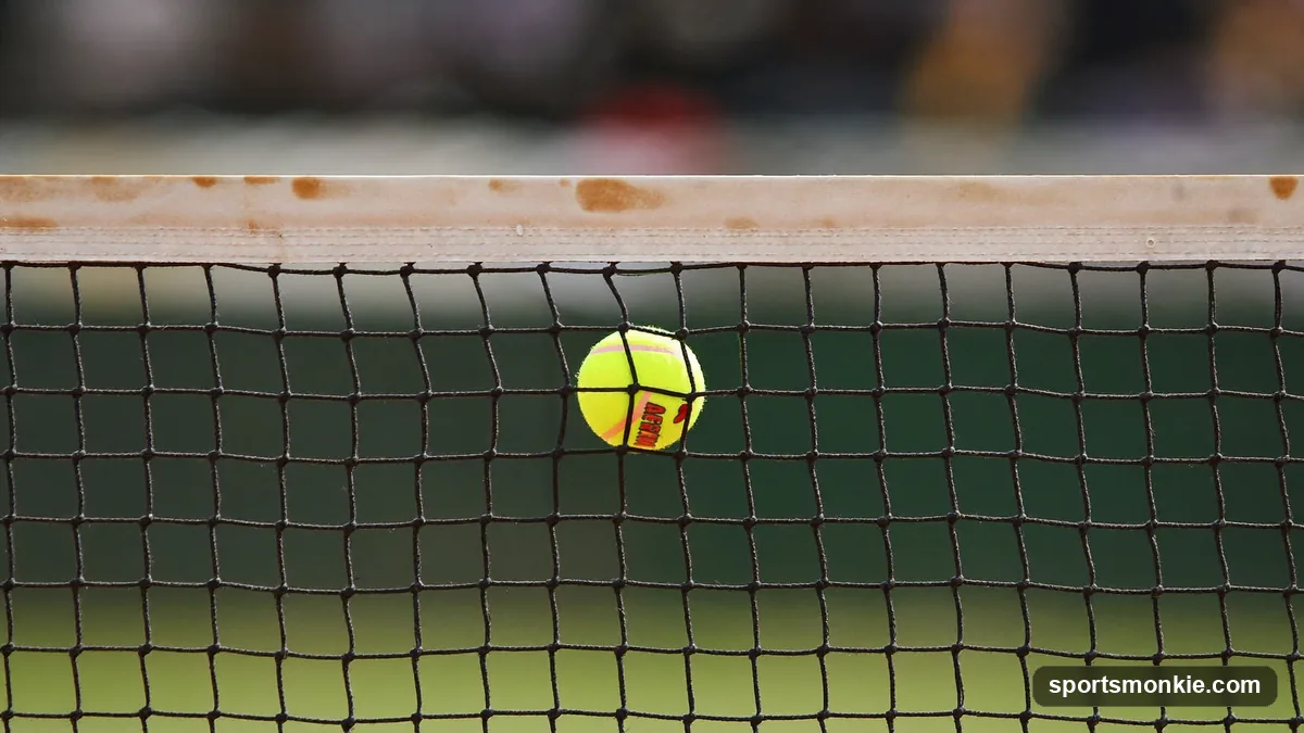 A pickleball clipping the top of the net during a serve on an outdoor court