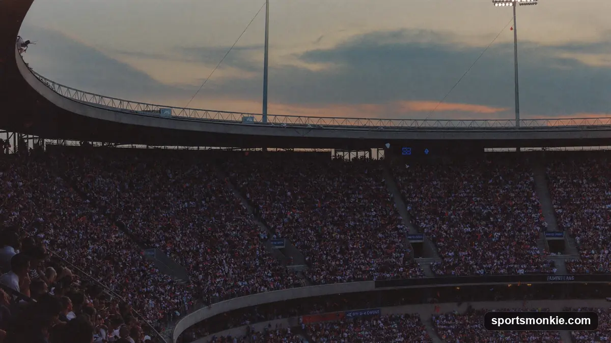 A vast packed sports stadium seen from high in the stands under floodlights