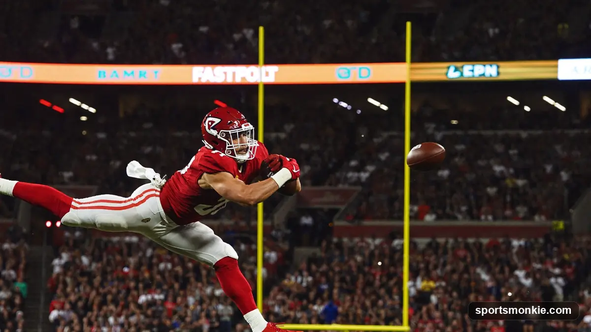 American football in the air above a defensive back on a stadium field