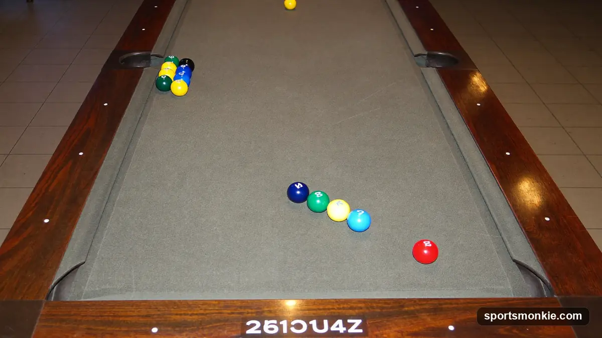 Long polished wooden shuffleboard table with pucks at the scoring end under warm bar light
