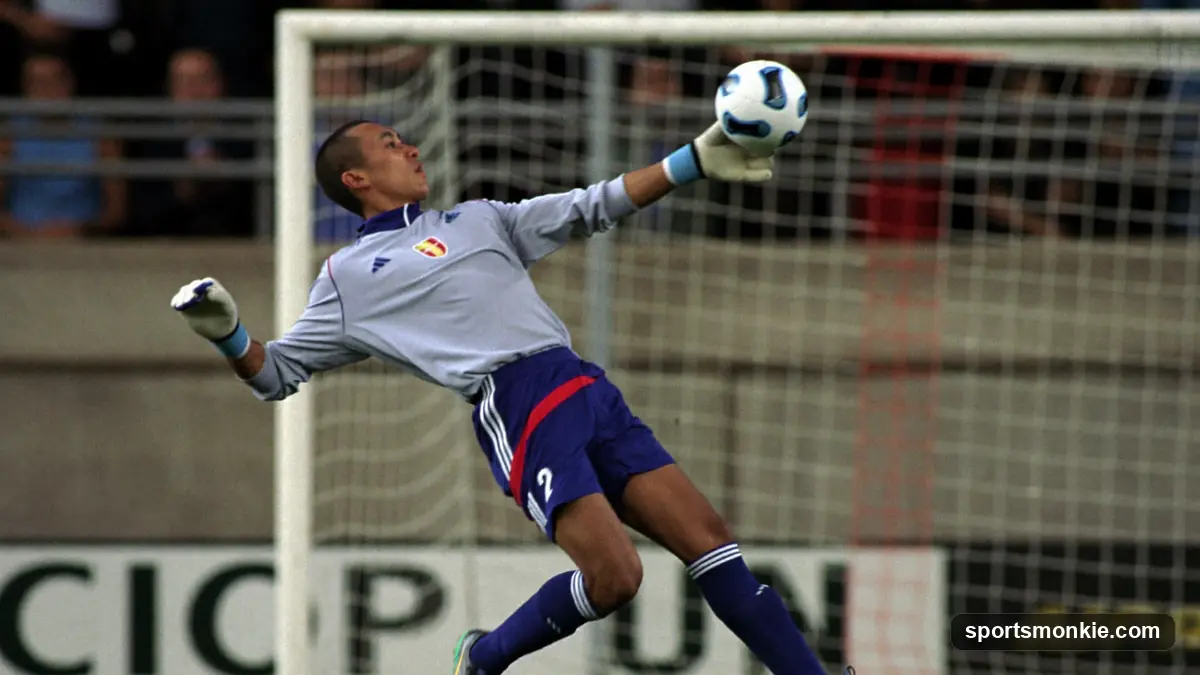Tall goalkeeper reaching up to tip a high shot over the crossbar