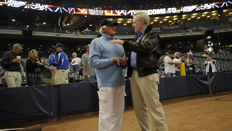 File photo from September 13, 2011: Bob Uecker, wearing a USS Milwaukee ball cap he had just been given, talks with Secretary of the Navy Ray Mabus on the field at Miller Park, now American Family Field. It predates the 2026 World Series by 15 years.