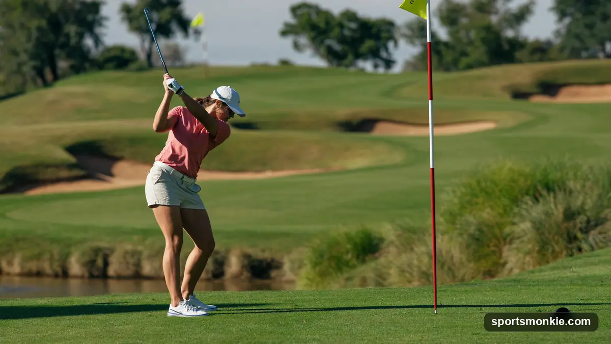 Amateur golfer hitting an iron approach shot from the fairway on a sunny day